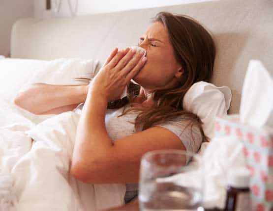 Image of a woman in bed feeling under the weather
